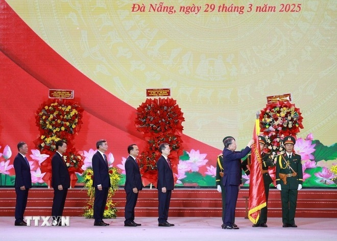Tổng Bí thư Tô Lâm gắn Huân chương Lao động hạng Nhất lên Cờ truyền thống của Thành phố Đà Nẵng. (Ảnh: TTXVN)