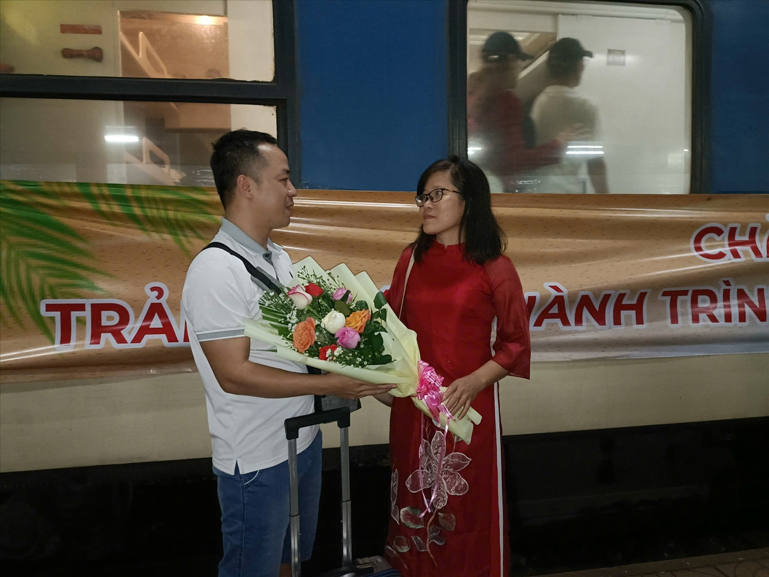 Bà Nguyễn Thị Kim Chung, Phó Giám đốc Sở Văn Hoá Thể thao và Du lịch Bình Định tặng hoa cho du khách đến Bình Định bằng chuyến tàu 