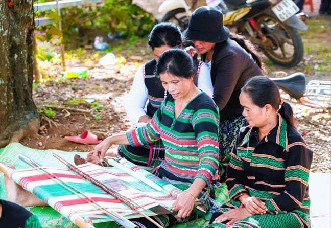Người có uy tín H’Jon ở bon Pi Nao, xã Nhân Đạo, huyện Đắk R’lấp miệt mài bên khung dệt và truyền dạy kỹ thuật dệt thổ cẩm cho chị em trong bon (Ảnh minh họa).