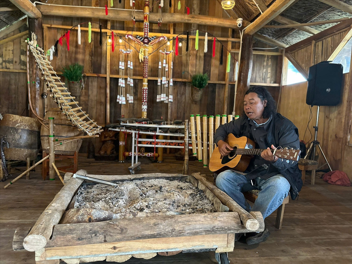 Nghệ sĩ Krajan Plin thể hiện ca khúc “K'Bing ơi em hãy về”  trong ngôi nhà sàn dưới chân núi Lang Biang.