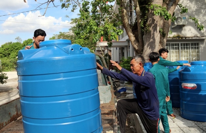 Người dân vui mừng nhận bồn chứa nước. Ảnh: Lê Sen 