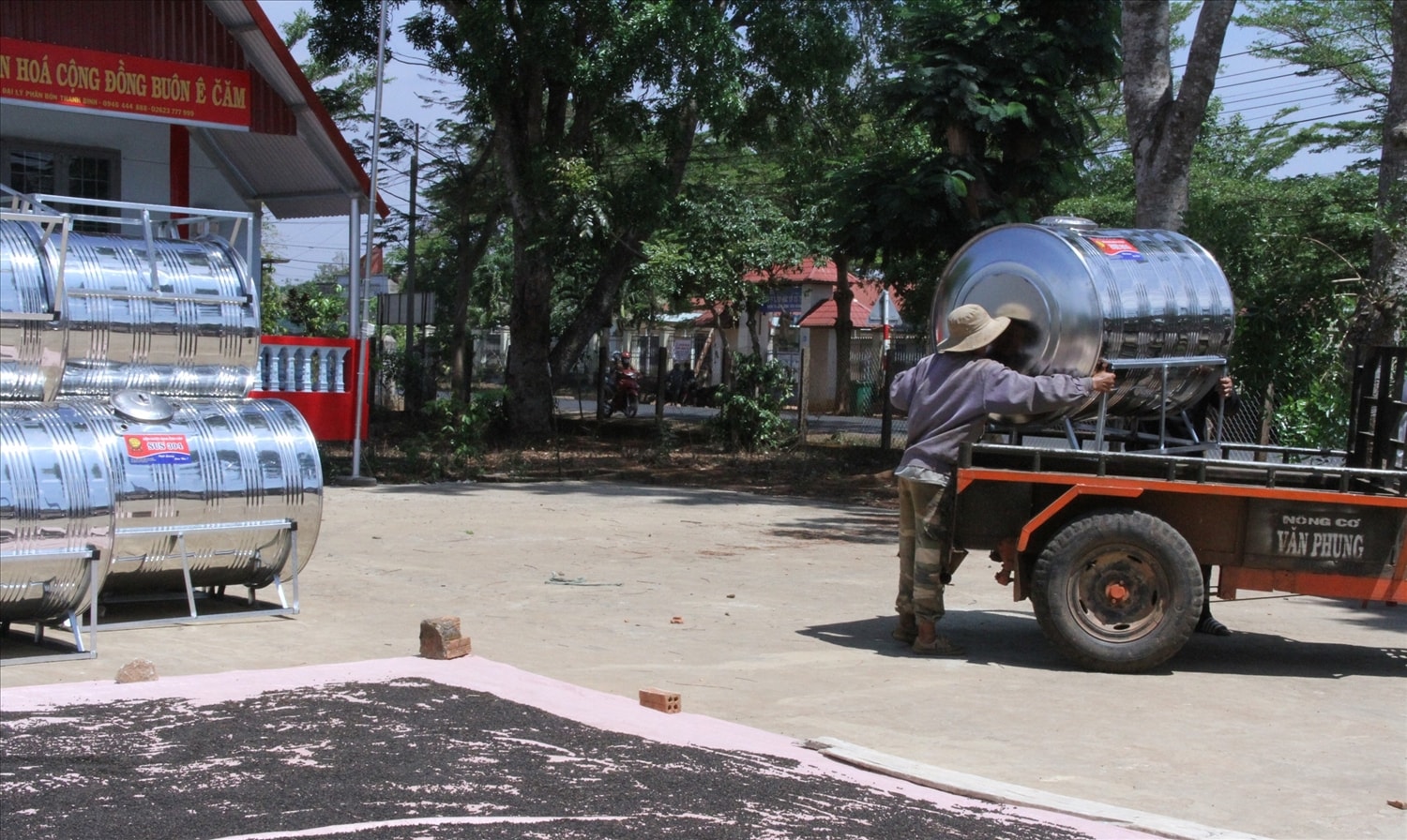 Người dân mang xe cày chở bồn nước