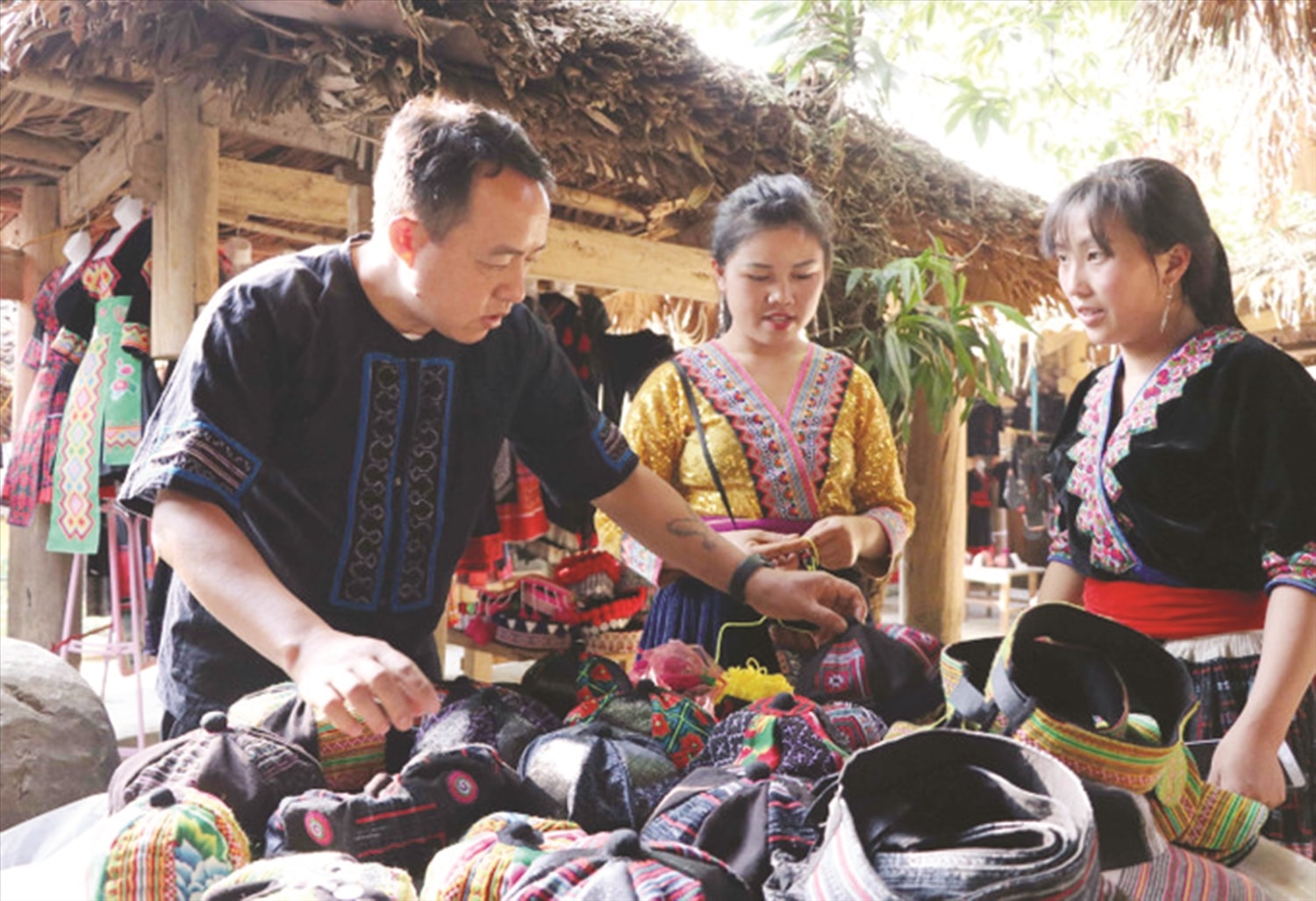 Ông Hảng A Xà hướng dẫn bà con về kinh doanh sản phẩm thổ cẩm ở chợ phiên.  Ảnh Nguyễn Oanh