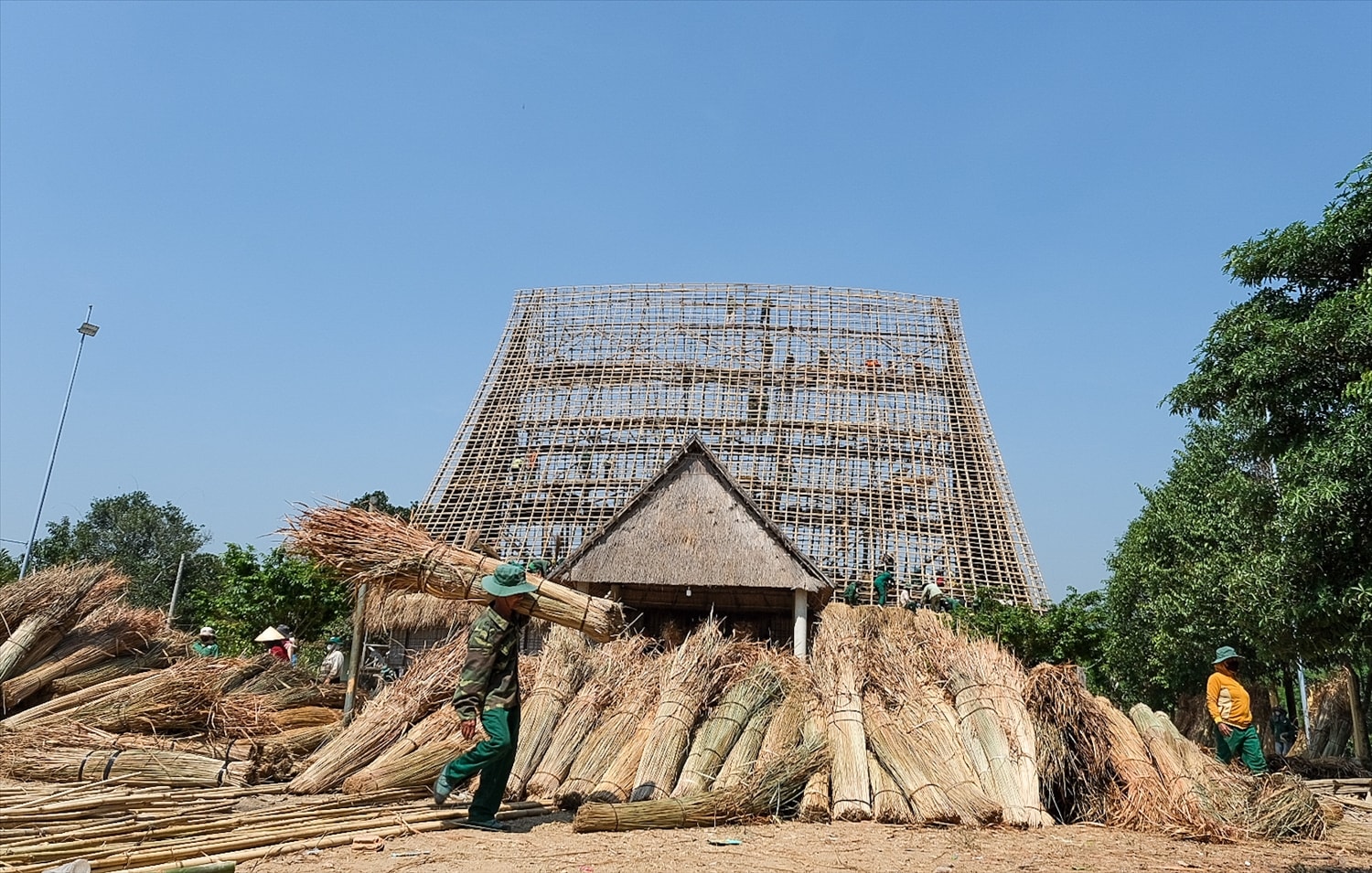 Mọi người cùng kiếm tranh, dây mây, tre nứa… để lợp lại mái nhà rông truyền thống của làng Mọi người cùng kiếm tranh, dây mây, tre nứa… để lợp lại mái nhà rông truyền thống của làng