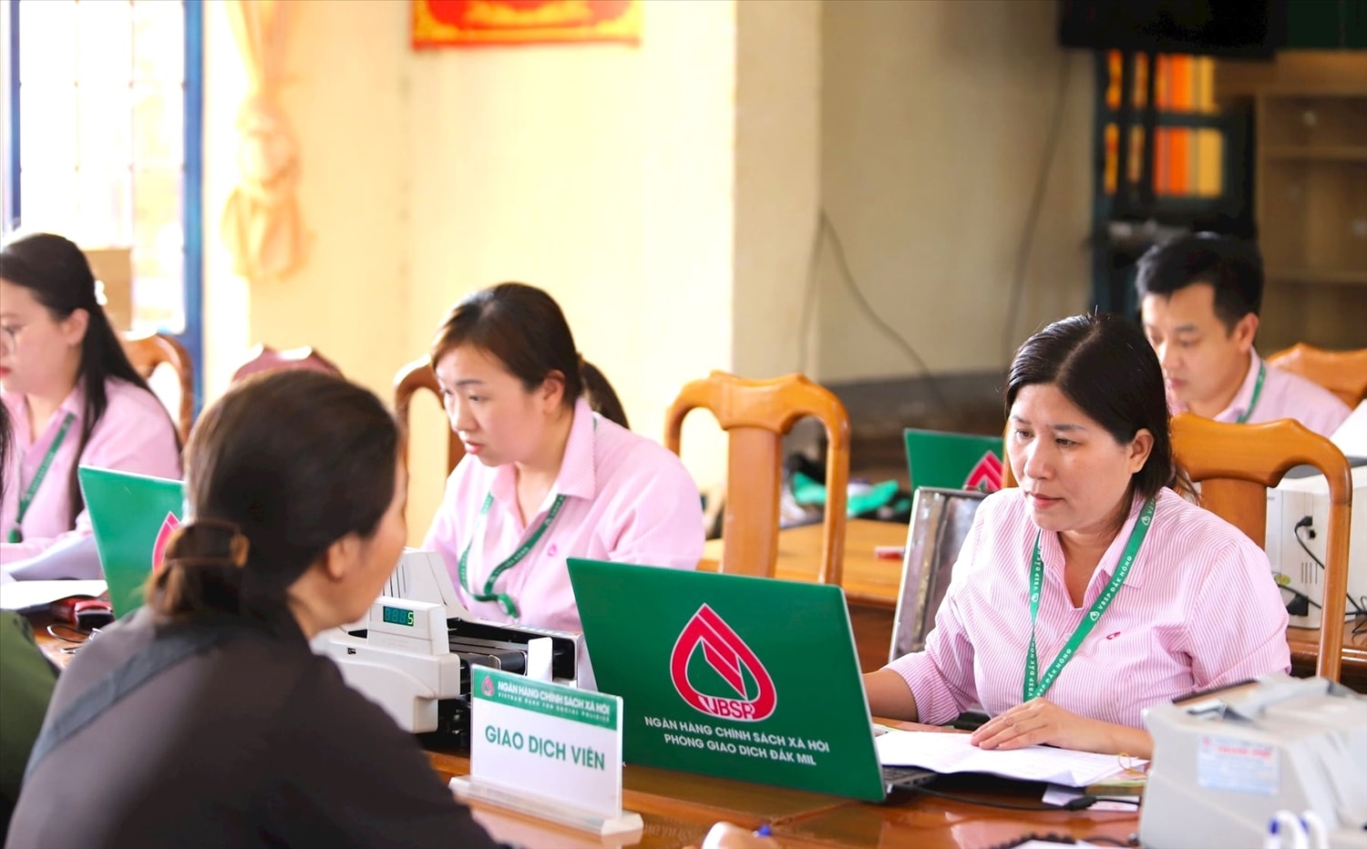 Cán bộ Phòng giao dịch NHCSXH huyện Đắk Mil (Đắk Nông) làm thủ tục giải ngân cho người dân vay vốn