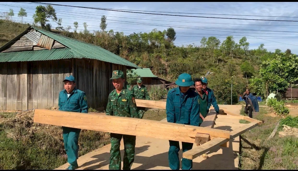 Cán bộ, chiến sỹ Đồn Biên phòng Đăk Plô và lực lượng dân quân xã Đăk Blô, huyện Đăk Glei, tỉnh Kon Tum giúp người dân xóa nhà tạm. (Ảnh: Ngọc Chí) 