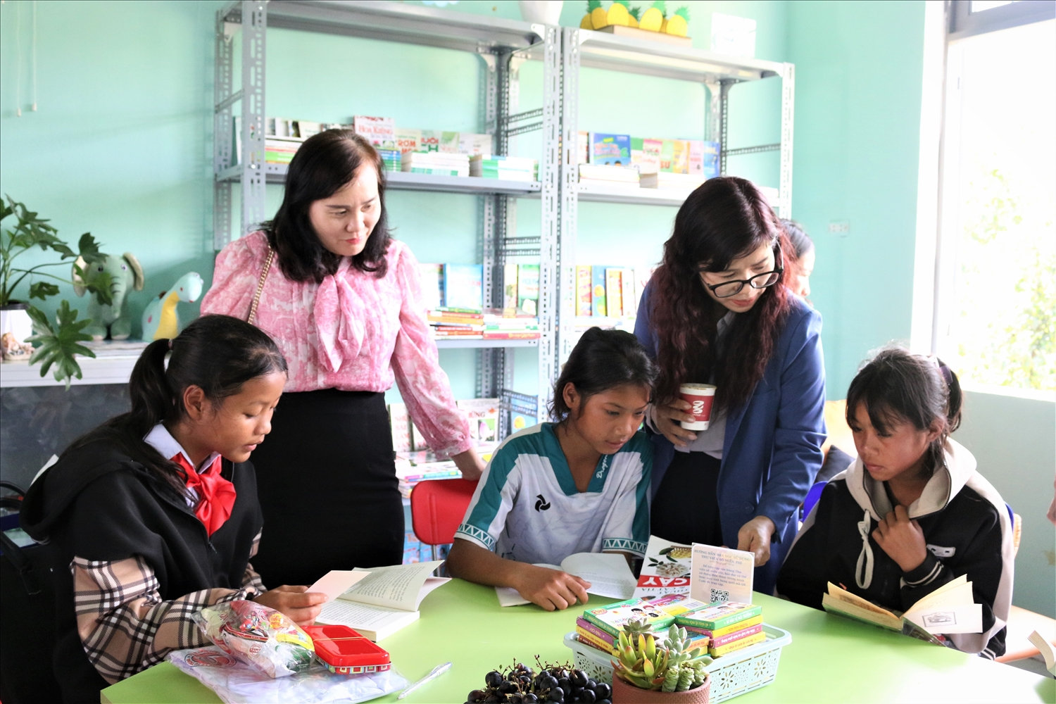 Bà Phạm Thị Trung (thứ 2 từ phải sang), Giám đốc Sở Giáo dục và Đào tạo tỉnh Kon Tum chia sẻ việc đọc sách cùng các em học sinh ở làng Long Năng
