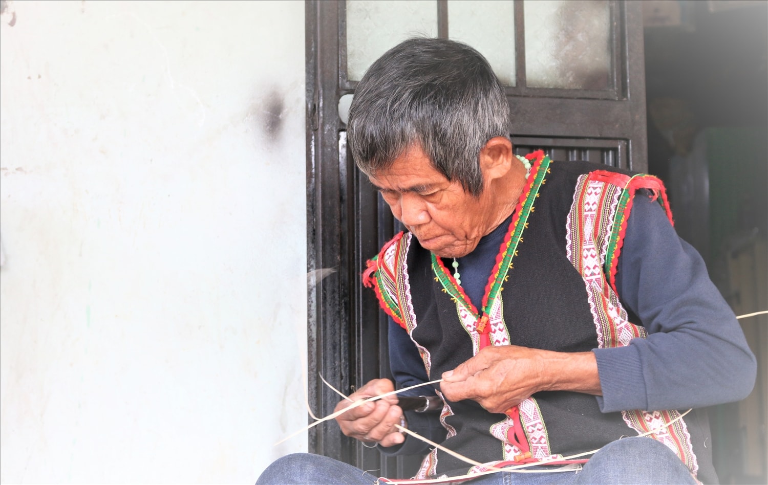 Nghệ nhân A Biu vẫn đang miệt mài chẻ từng nan lạt, vuốt bóng bẩy và đều nhau để đan những chiếc gùi truyền thống của người Xơ Đăng