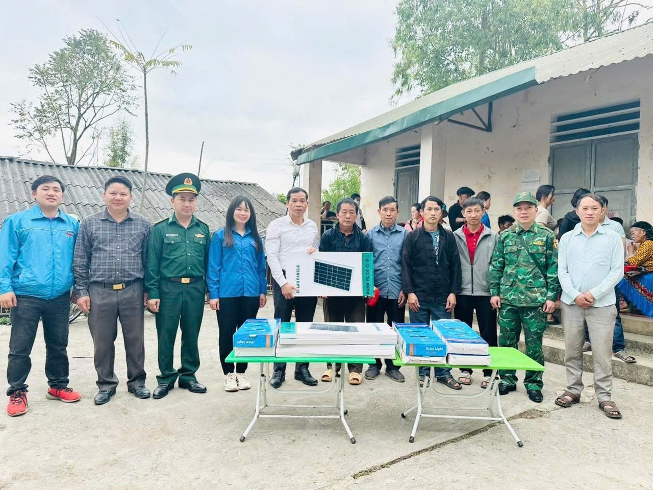 Bia thư Đảng ủy thị trấn Đồng Văn (áo trắng ở giữa ) trao tặng đèn năng lượng mặt trời cho nhân dân thôn biên giới Mã Pắng, thị trấn Đồng Văn (Hà Giang)