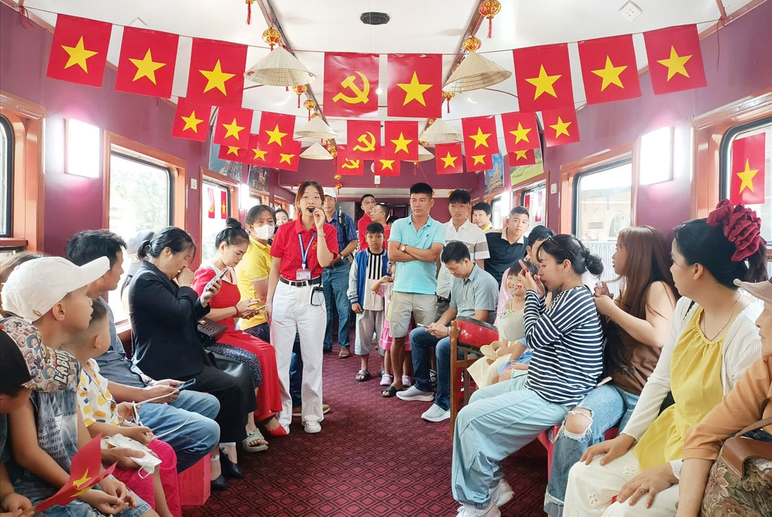 Du khách chăm chú lắng nghe thuyết minh sinh động về lịch sử, văn hóa Bình Định suốt hành trình tàu hỏa