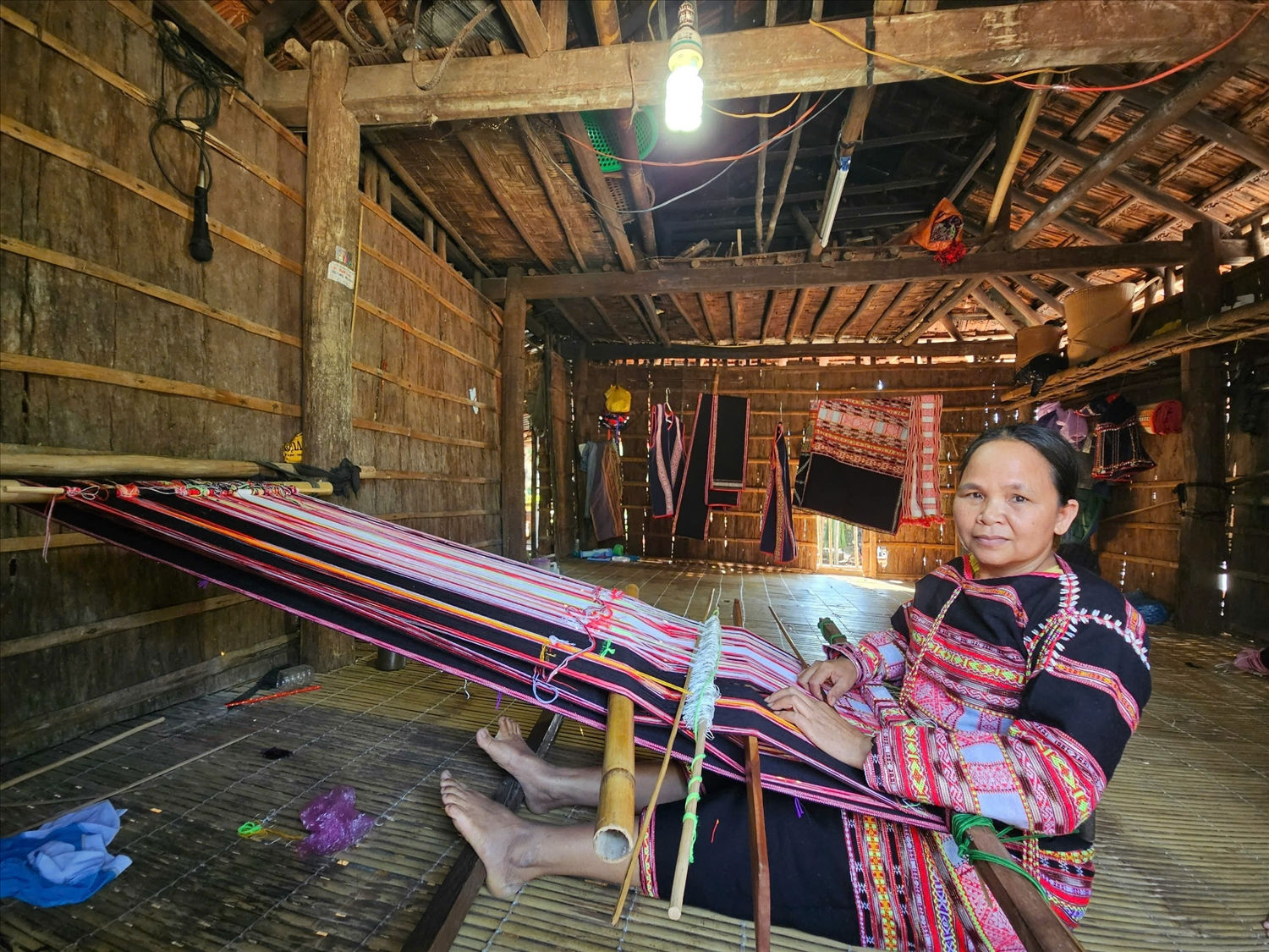 Bà Đinh Thị Bung bên khung dệt thổ cẩm
