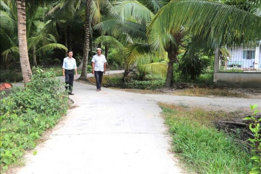 Đường đi do ông Kim Ruône (bên phải) Bí thư Chi bộ, Người có uy tín ấp Bót Chếch, xã Lương Hòa, huyện Châu Thành, tỉnh Trà Vinh hiến đất xây dựng. (Ảnh: Thanh Hòa). Đường đi do ông Kim Ruône (bên phải) Bí thư Chi bộ, Người có uy tín ấp Bót Chếch, xã Lương Hòa, huyện Châu Thành, tỉnh Trà Vinh hiến đất xây dựng. (Ảnh: Thanh Hòa).