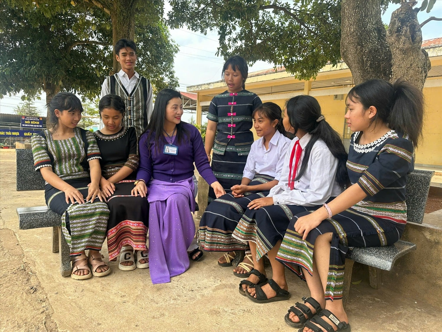 Cô giáo Nguyễn Thị Xuân Loan, Hiệu trưởng Trường THCS Đạ Ròn đang trò chuyện, động viên với các thành viên trong đội cồng chiêng.