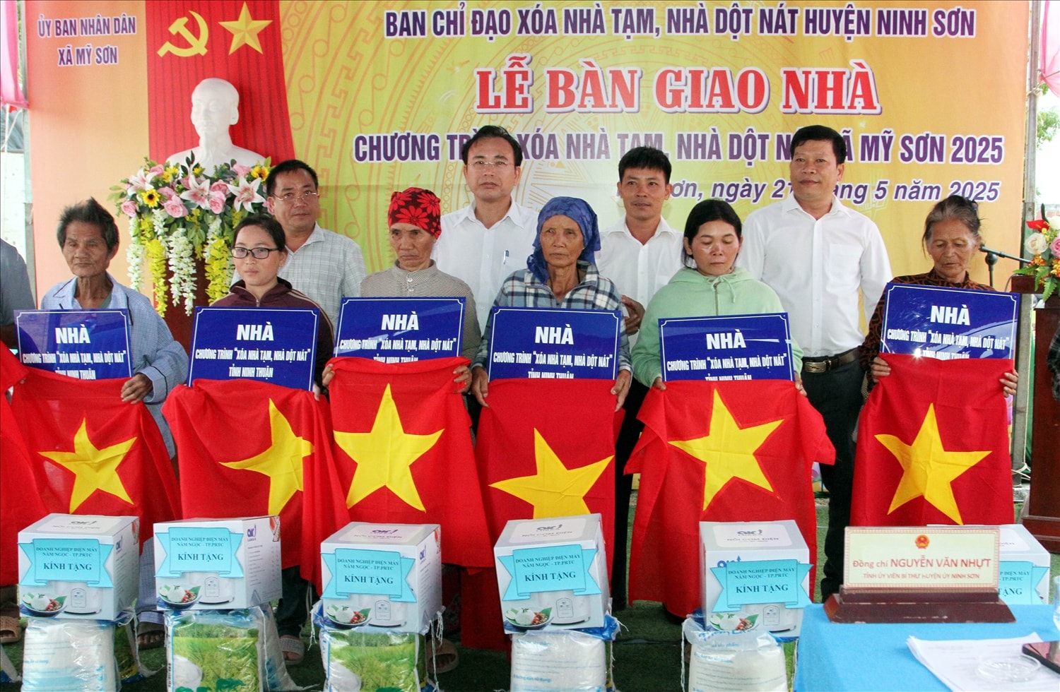 Cán bộ lãnh đạo huyện Ninh Sơn trao bảng tượng trưng, cờ Tổ quốc, quà tặng cho các hộ nhận bàn giao nhà. 