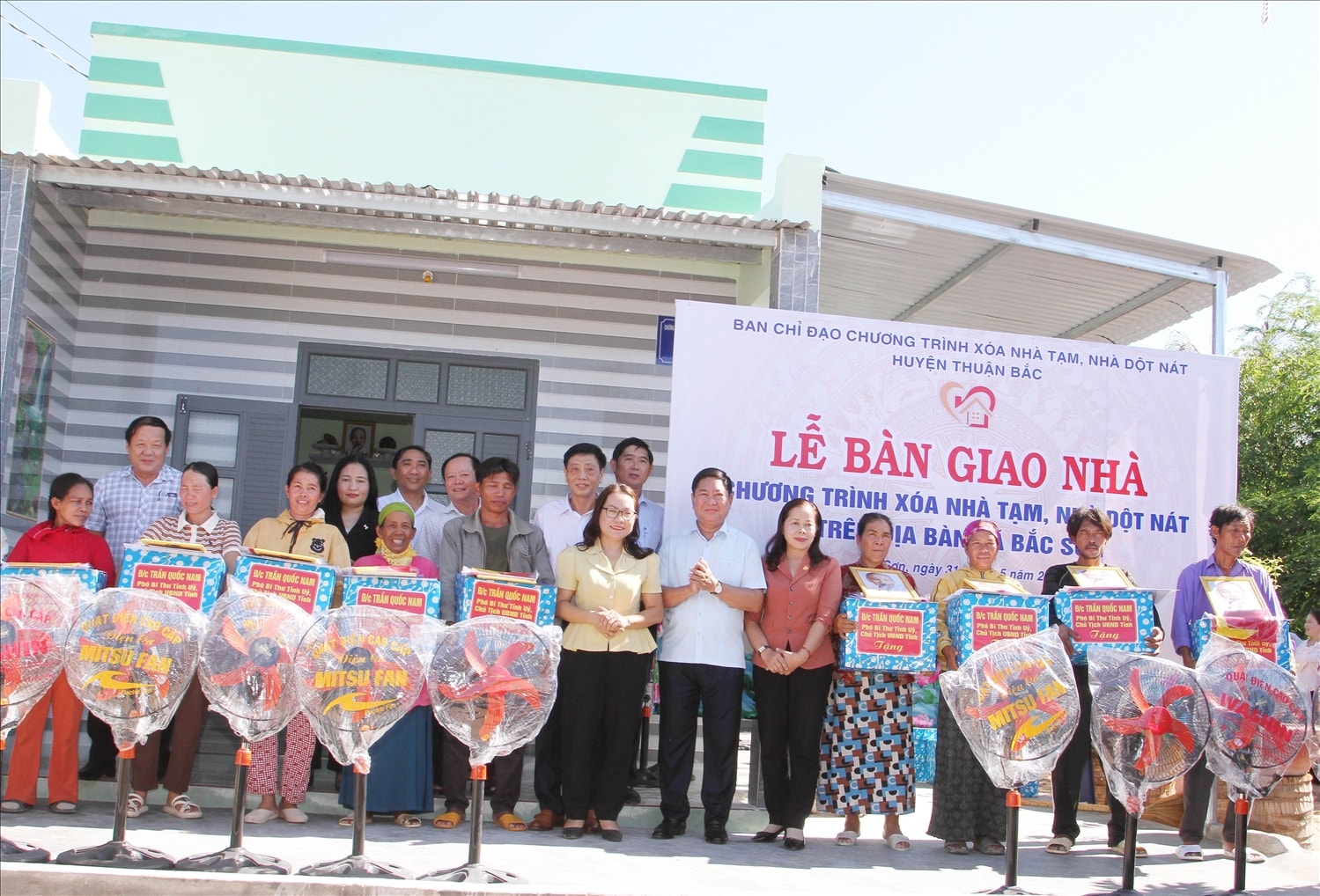 Ông Trần Quốc Nam, Chủ tịch UBND tỉnh và các đại biểu trao bảng tượng trưng và quà tặng cho các hộ nhận bàn giao nhà. 