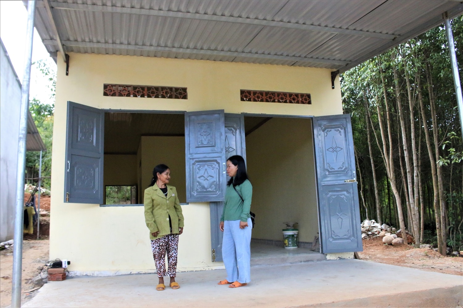Bà Y Búc (bên trái), thôn 3, xã Đăk Pne, huyện Kon Rẫy được hỗ trợ 60 triệu và bà thêm vào 40 triệu để làm căn nhà khang trang, rộng rãi