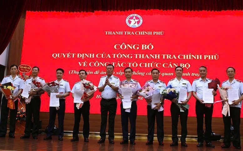 Tổng Thanh tra Chính phủ Đoàn Hồng Phong trao quyết định và tặng hoa chúc mừng các cán bộ được điều động, tiếp nhận và bổ nhiệm - Ảnh: TTCP