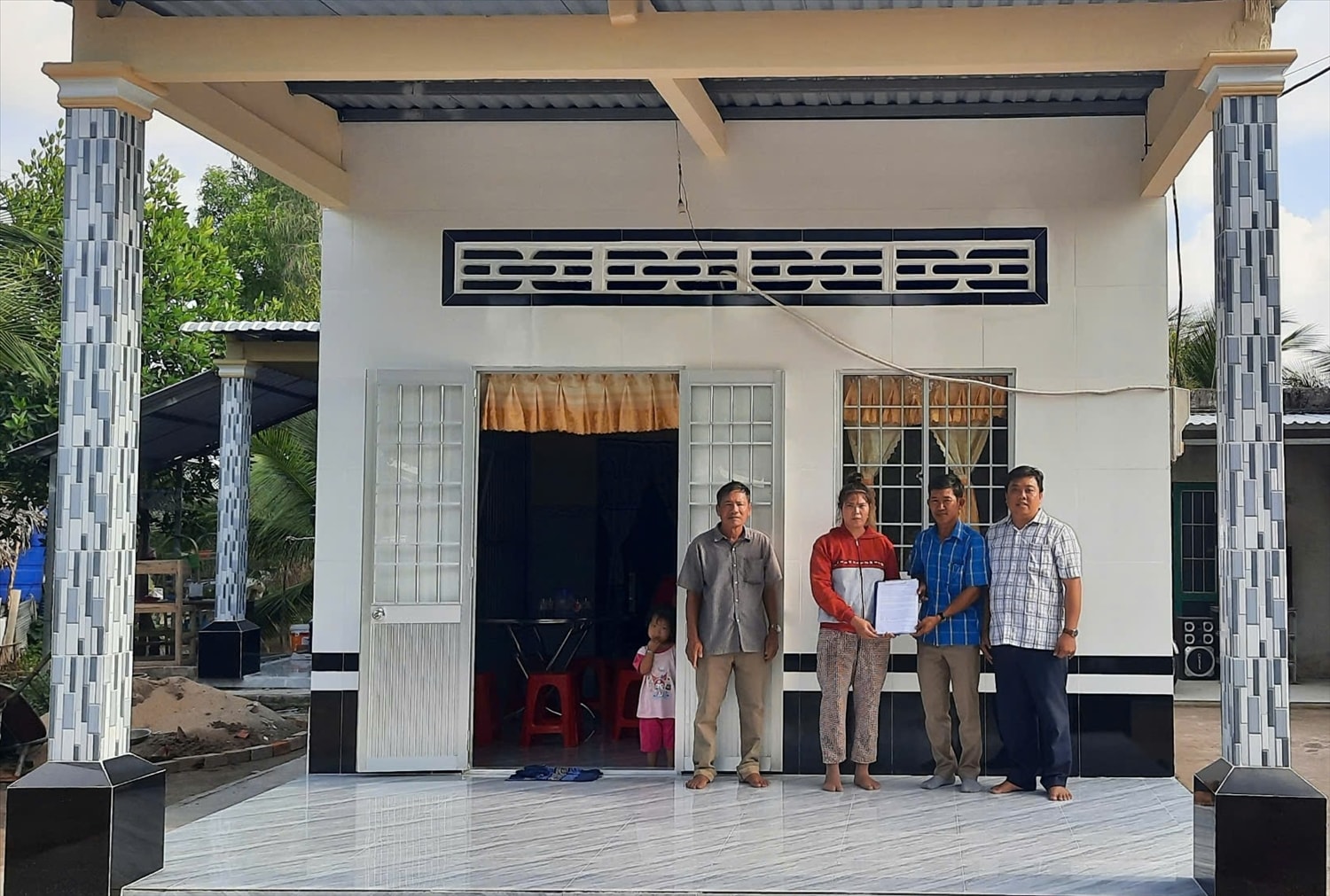 Bà Hữu Thị Lan ở ấp 11, xã Thới Bình, huyện Thới Bình  (Cà Mau ) được nhận nhà trước Tết cổ truyền Chôl Chnăm Thmây năm 2025 ( Trong ảnh: Đại diện gia đình bà Lan nhận Quyết định  trao nhà từ chính quyền địa phương )  