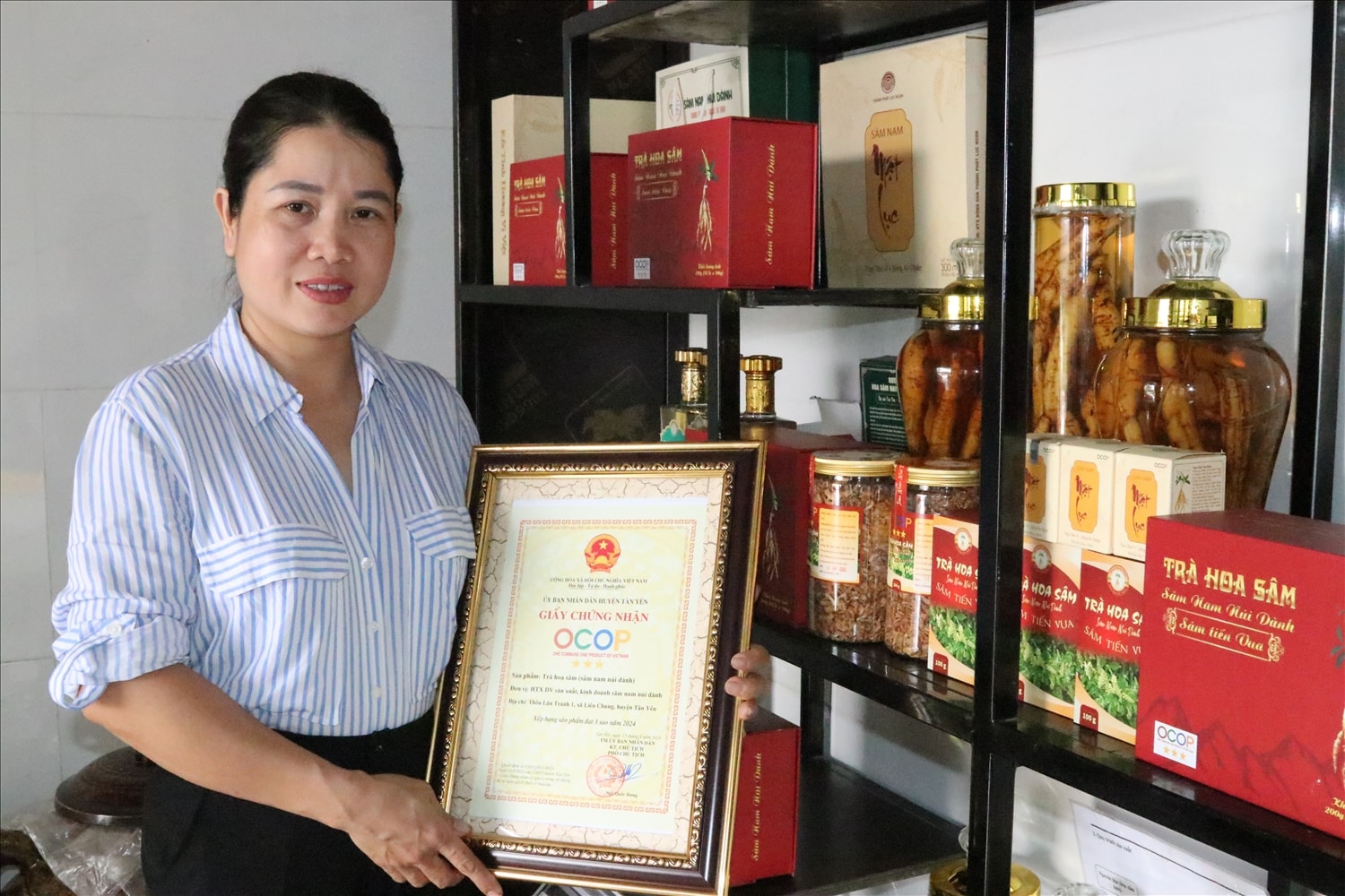 Chị Trần Thị Thanh Giám đốc HTX sản xuất và DVKD sâm nam núi Dành Thanh Vinh  bên các sản phẩm của HTX