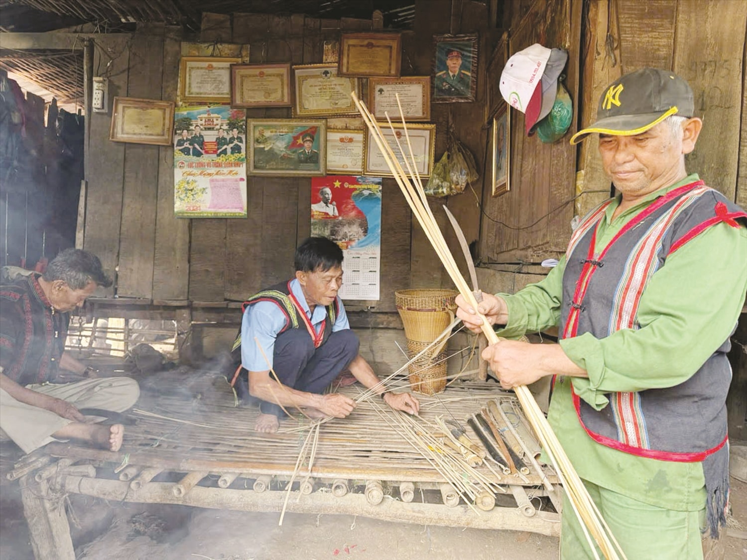 Ông Điểu Vem (bìa phải) cùng các già làng, Người có uy tín trong ấp tập trung đan lát