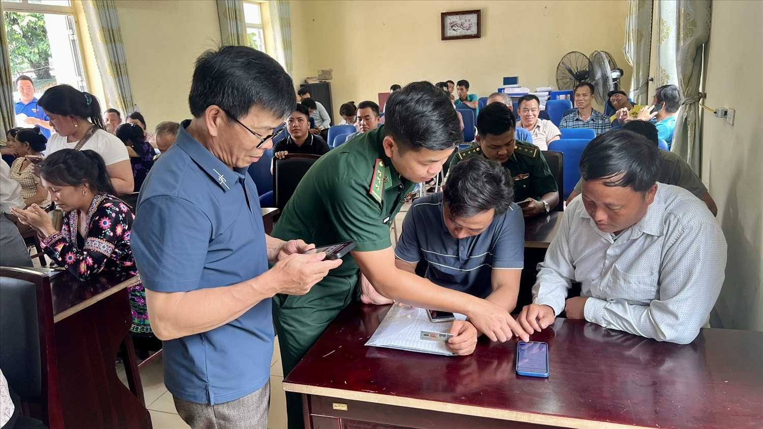 Cán bộ Đồn Biên phòng Pa Tần hướng dẫn cán bộ, công chức xã sử dụng các ứng dụng hỗ trợ giải quyết công việc trên điện thoại.