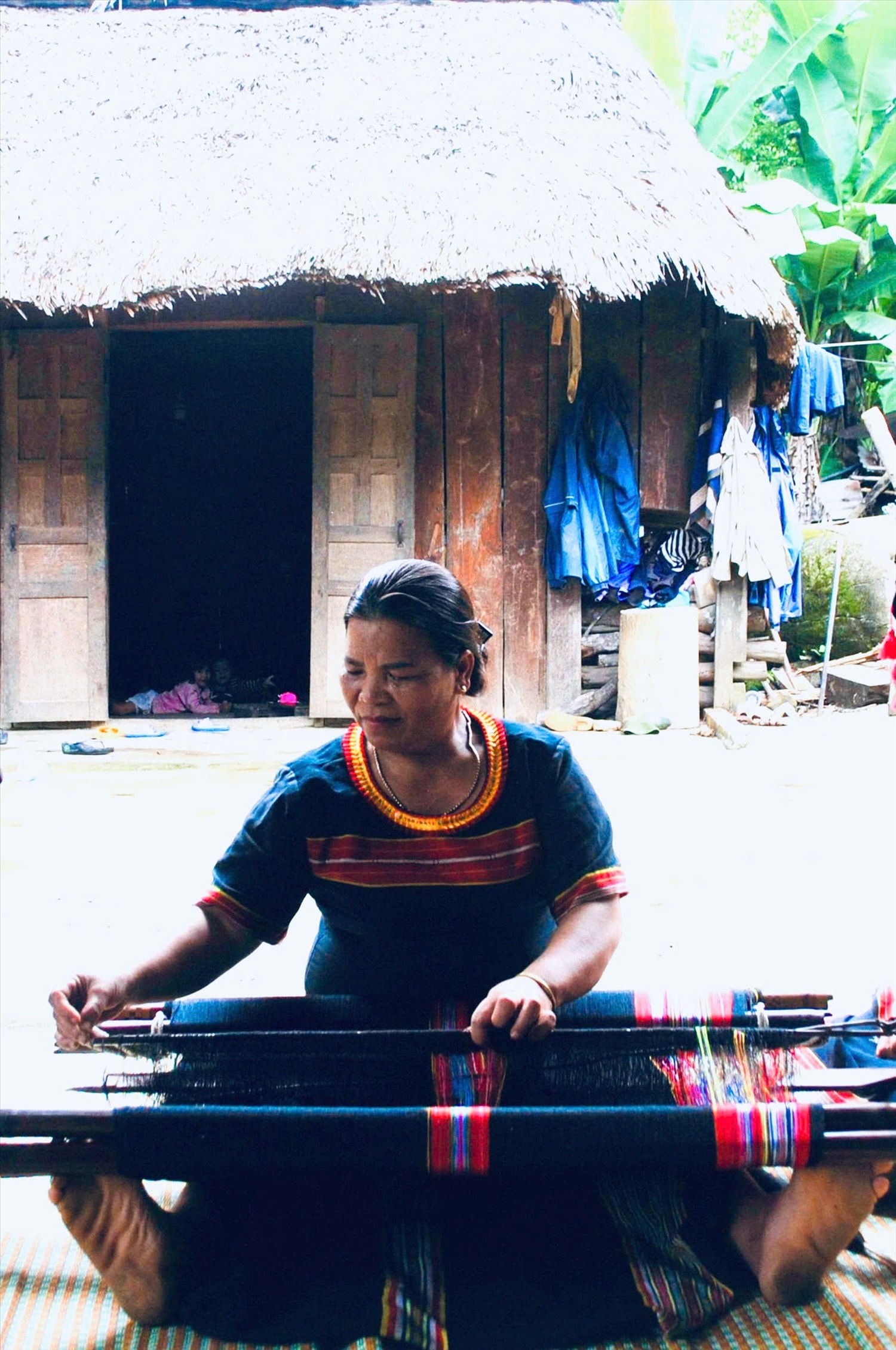 Bà Kring Thị Viết (65 tuổi) dân tộc Ve, ở thôn 49a, xã Đắc Pring, thành phố Đà Nẵng đang truyền nghề về cách tạo hoa văn trên nền tấm thổ cẩm. Ảnh: Văn Sơn