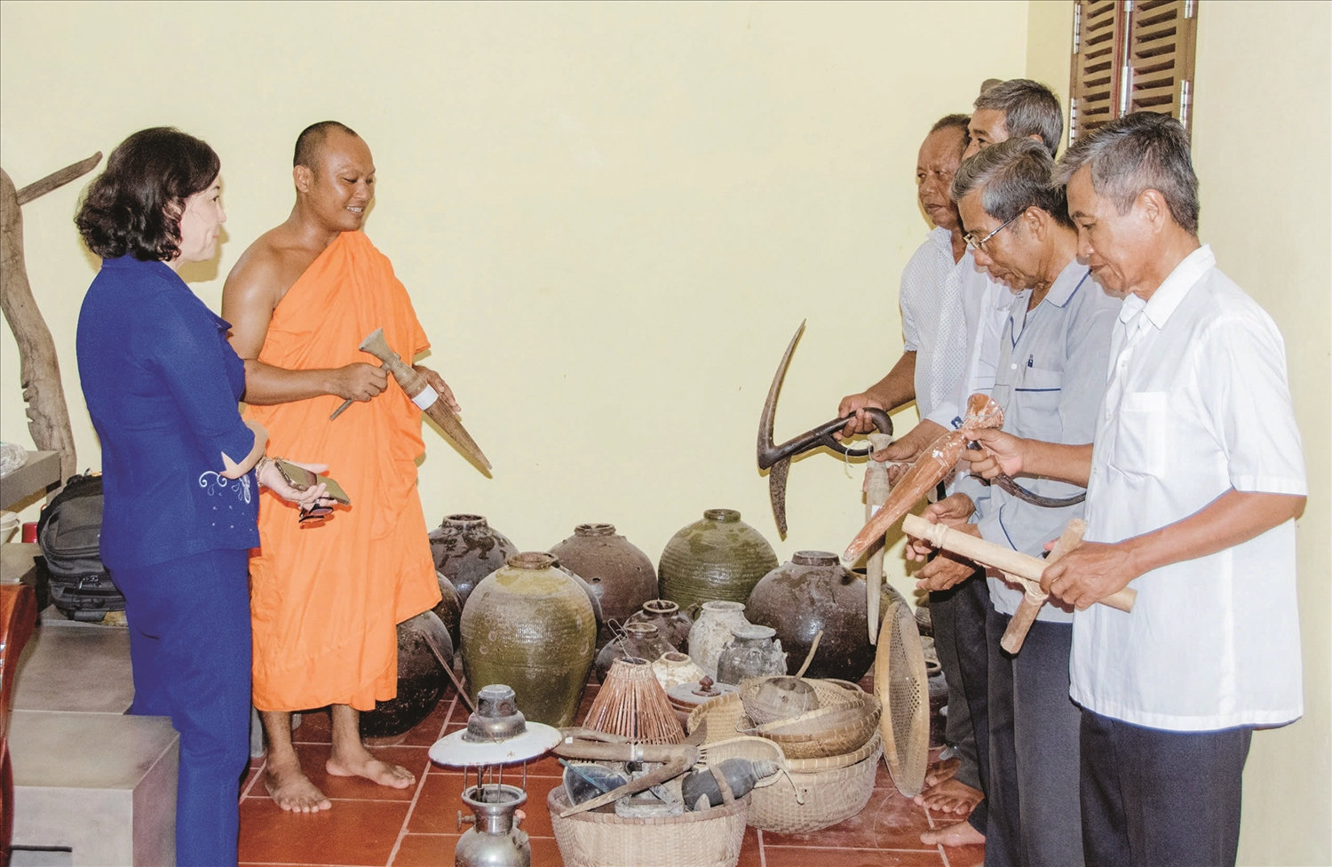 Đại đức Trương Văn Tuấn cùng các Phật tử  bên những nông cụ do chính Đại đức sưu tầm