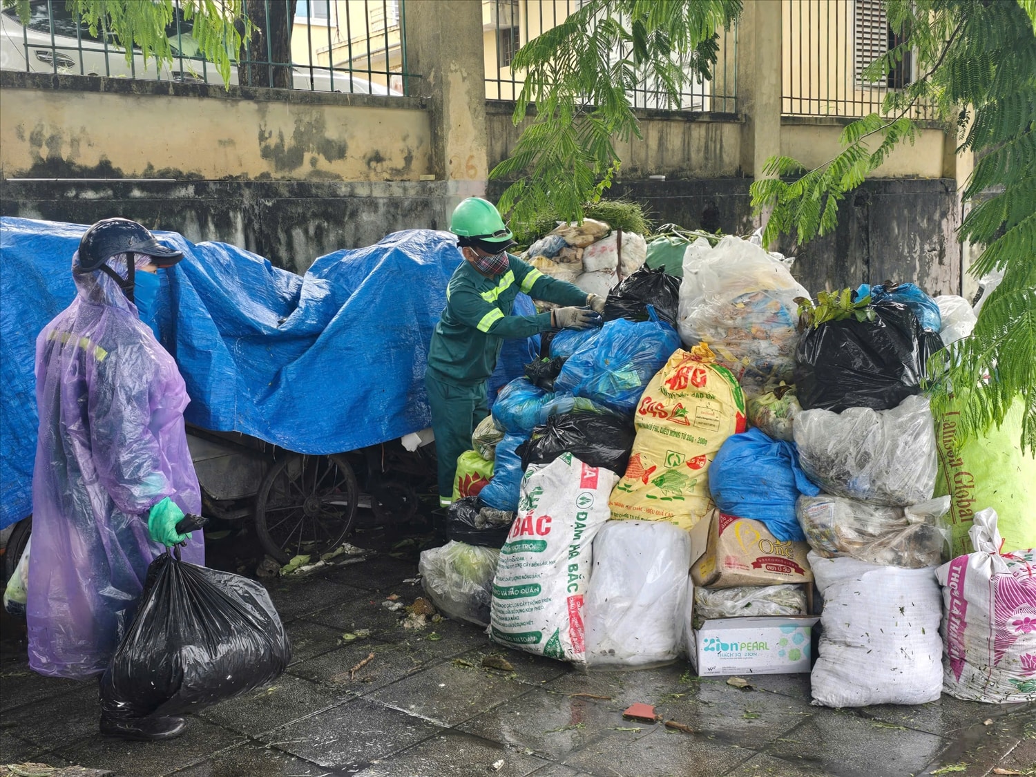 “Tạm thời rác nhiều quá, chúng tôi phải che bạt lên. Nhưng để thế này vài hôm thì mùi hôi thối kinh khủng. Chúng tôi cũng chưa biết các cơ quan chức năng sẽ giải quyết thế nào cho hợp lý”, một công nhân môi trường cho biết. (Ảnh: Mỹ Dung)
