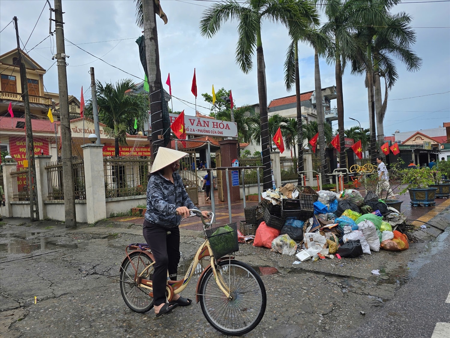 Chị Nguyễn Thị Lan Anh, trú tại phường Cửa Ông, than thở: “Gần một tuần rồi không ai đến thu rác. Rác đầy từ ngoài đường, đến trước cửa nhà văn hóa, sát bệnh viện… Nếu cứ tiếp diễn thế này, vài ngày nữa chắc rác cao đến đầu người.” (Ảnh: Mỹ Dung)
