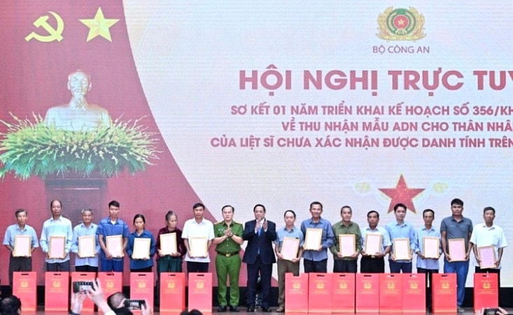 Thủ tướng Chính phủ Phạm Minh Chính trao Thông báo kết quả giám định ADN hài cốt liệt sĩ cho đại diện thân nhân các gia đình liệt sĩ. (Ảnh: Trần Hải) 