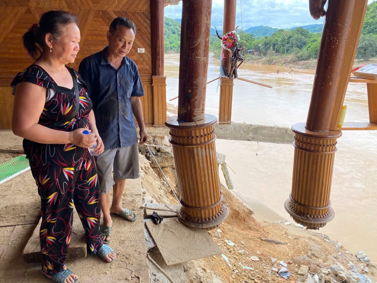 Vợ chồng ông Đậu Văn Sơn thẩn thờ nhìn ngôi nhà đã bị lũ phá hỏng