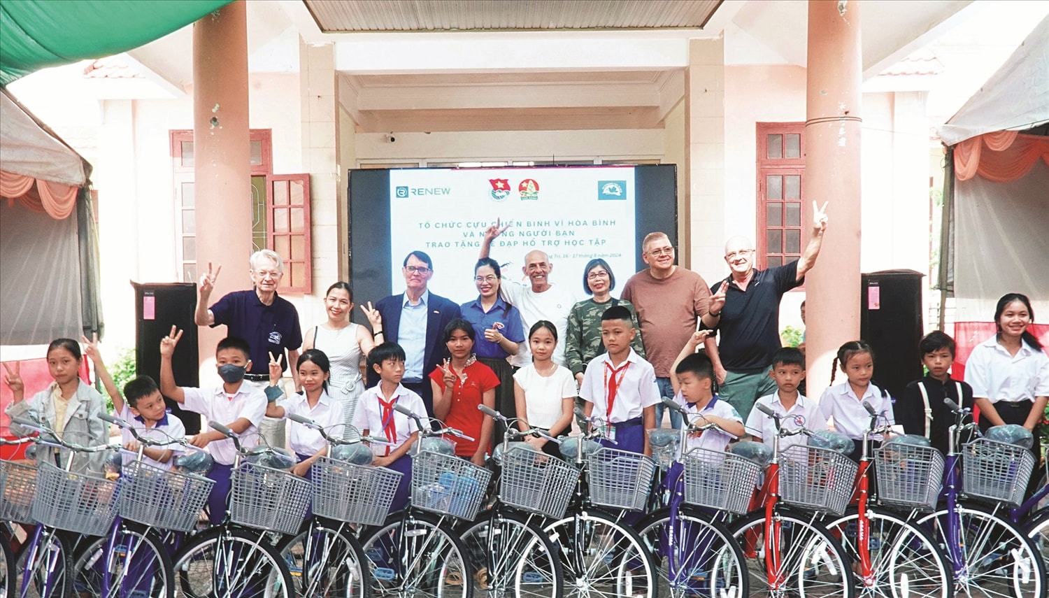 Cựu chiến binh Mỹ và đại biểu chụp ảnh lưu niệm với học sinh huyện miền núi Hướng Hóa  (tên địa danh cũ trước sáp nhập), tỉnh Quảng Trị trong buổi Lễ trao xe đạp. Ảnh minh họa