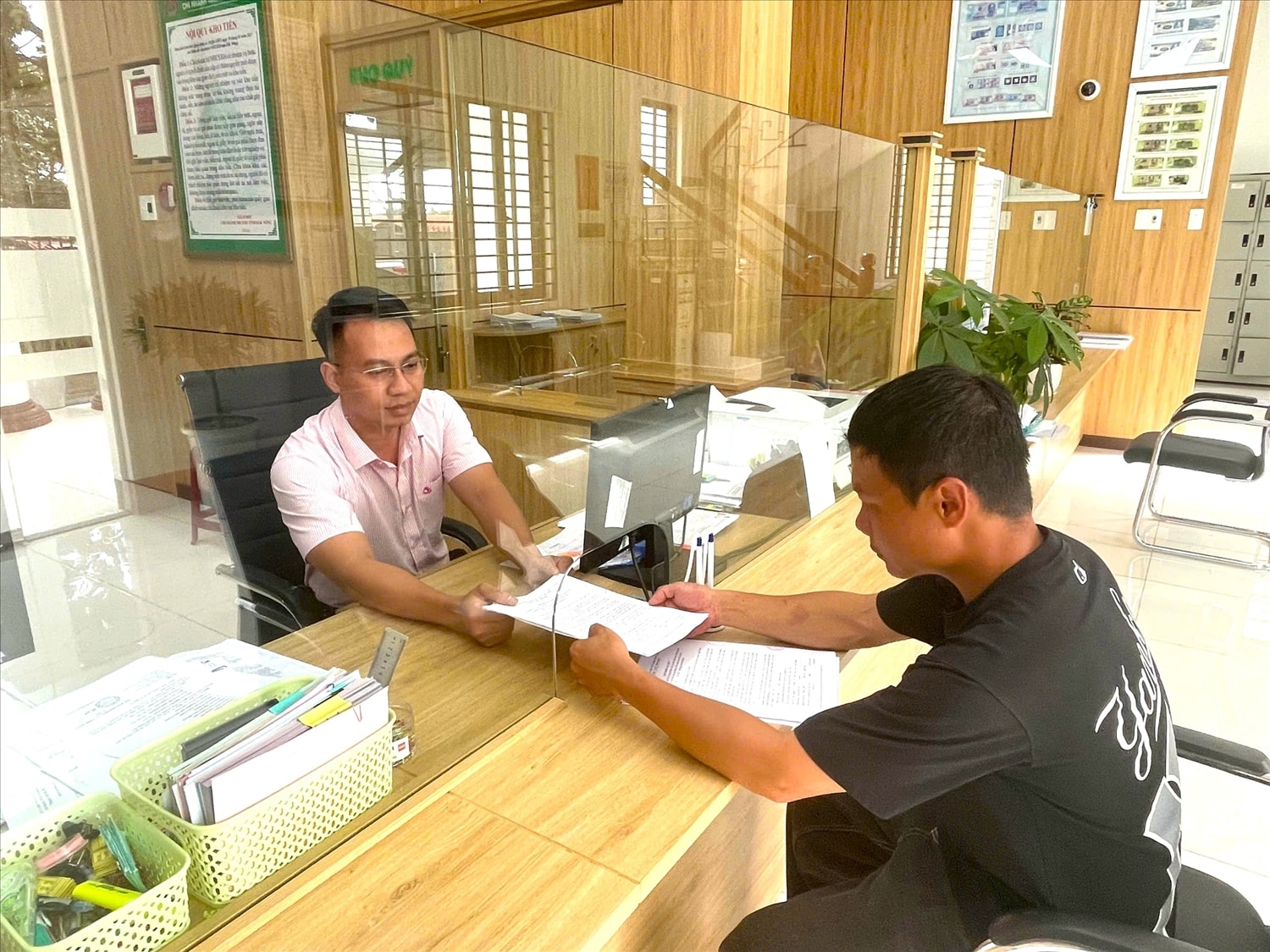 Cán bộ Phòng Giao dịch NHCSXH Đắk Mil tiếp người dân tại điểm giao dịch