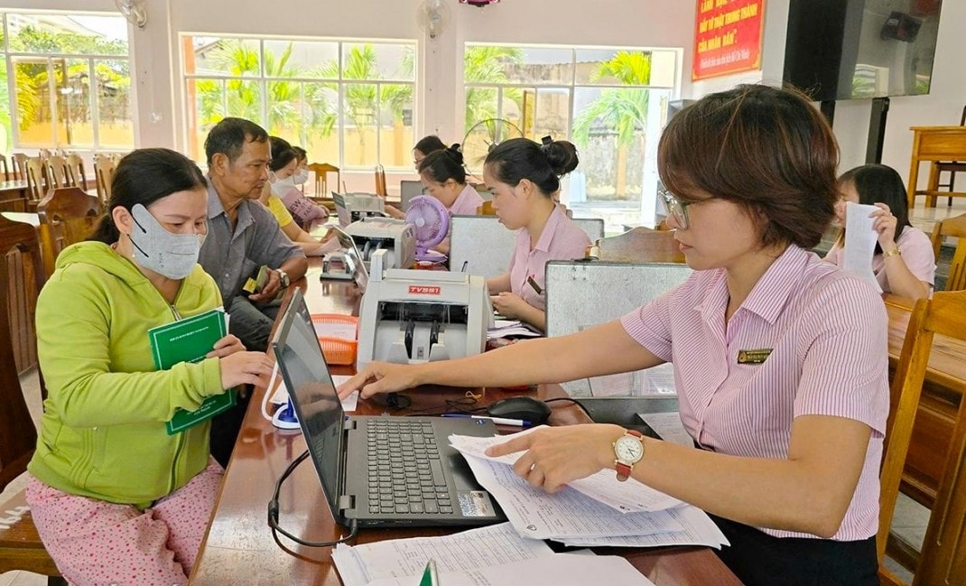 Bà Đặng Thị Nga (bìa trái), hộ vay ở thôn Phước Lộc làm thủ tục trả nợ vay vốn chương trình hộ nghèo tại điểm giao dịch phường Phú Yên (Đắk Lắk)