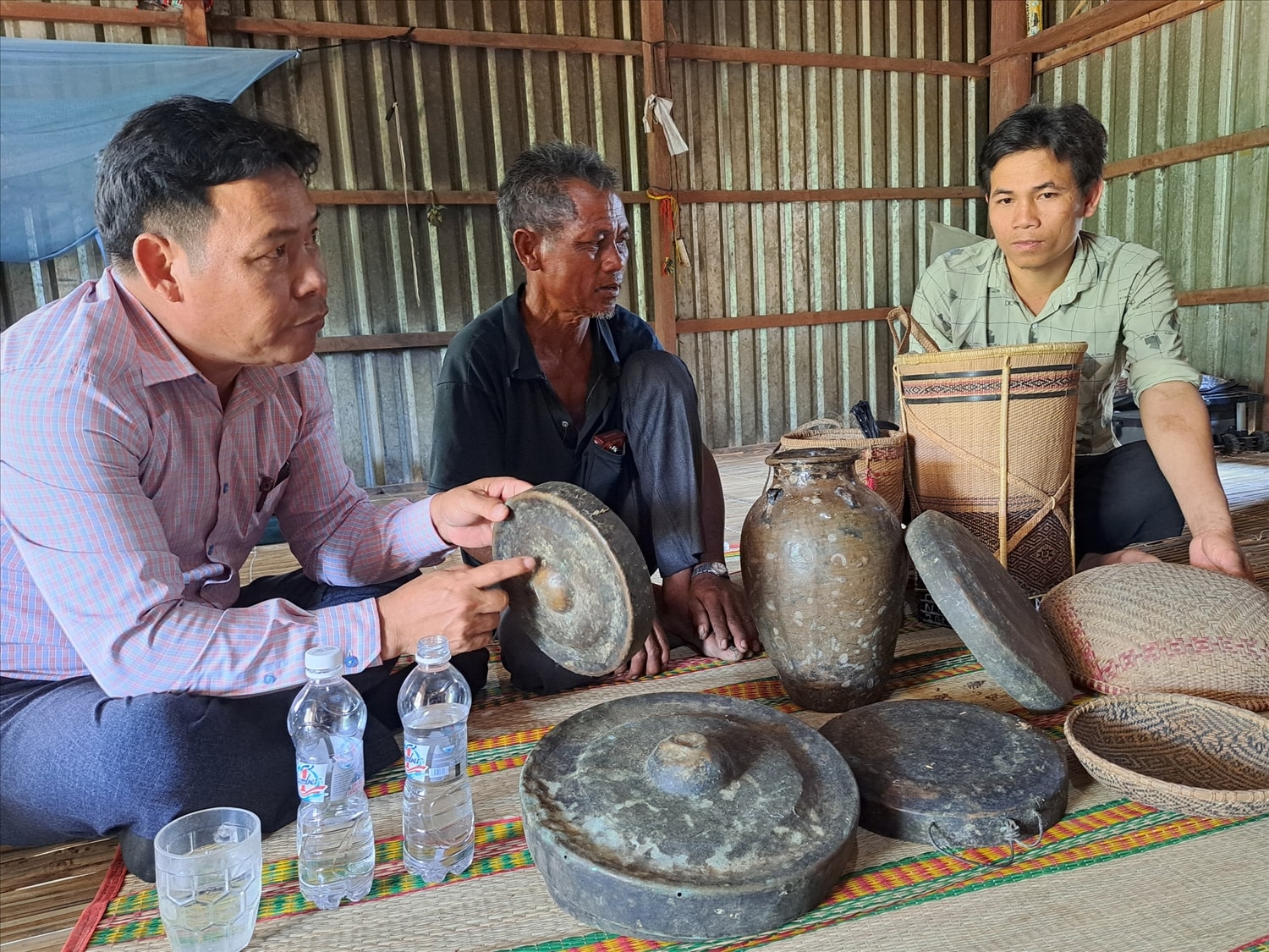 Già Đinh Văn Thảo (giữa) và bộ chiêng quý của mình. (Ảnh Huy Trường).