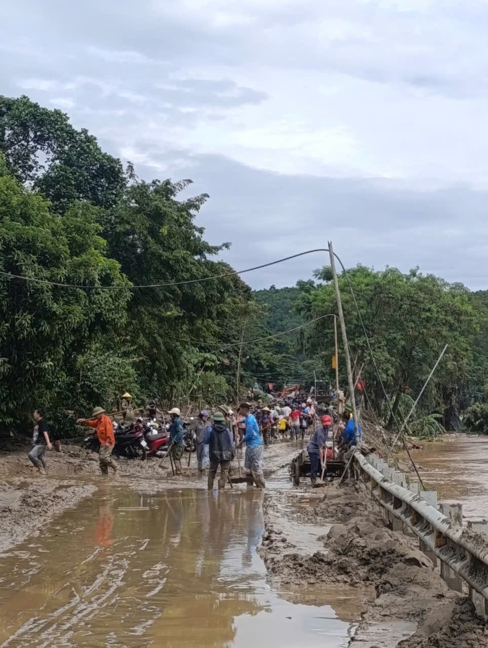 Xã Tam Quang chủ động huy động người dân các bản làng không bị ngập lũ, tham gia dọn dẹp bùn đất, thông tuyến quốc lộ 7 - Ảnh:  Thanh Hải