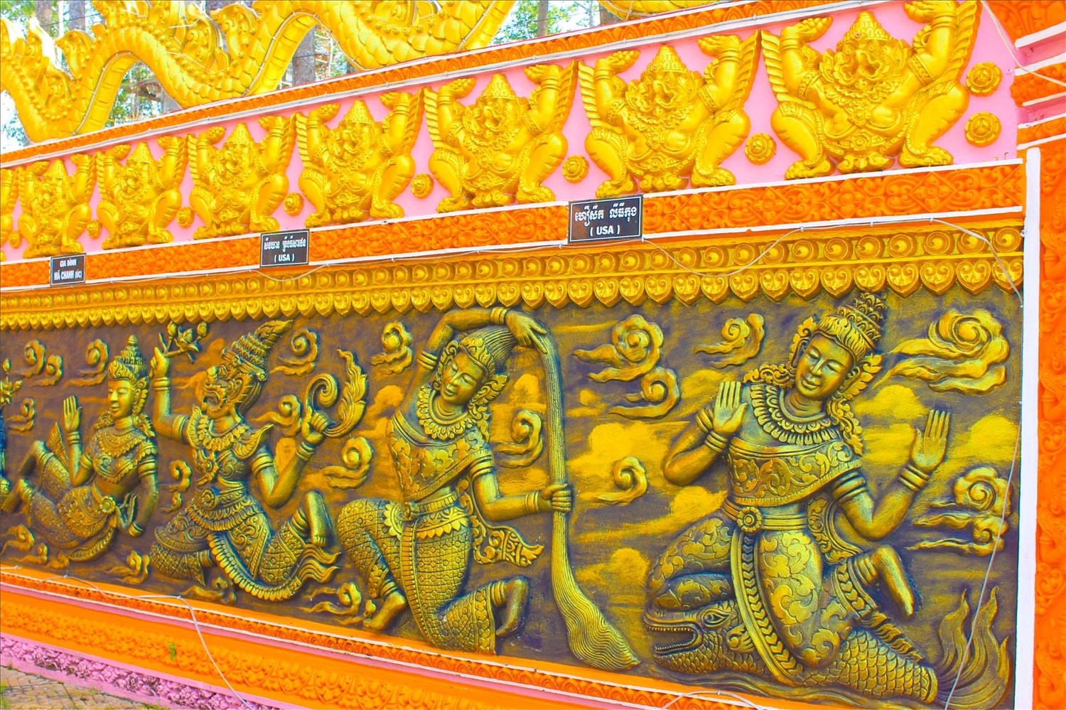Bức tường trước cổng chùa với những họa tiết, hình ảnh được đắp nổi đẹp mắt.