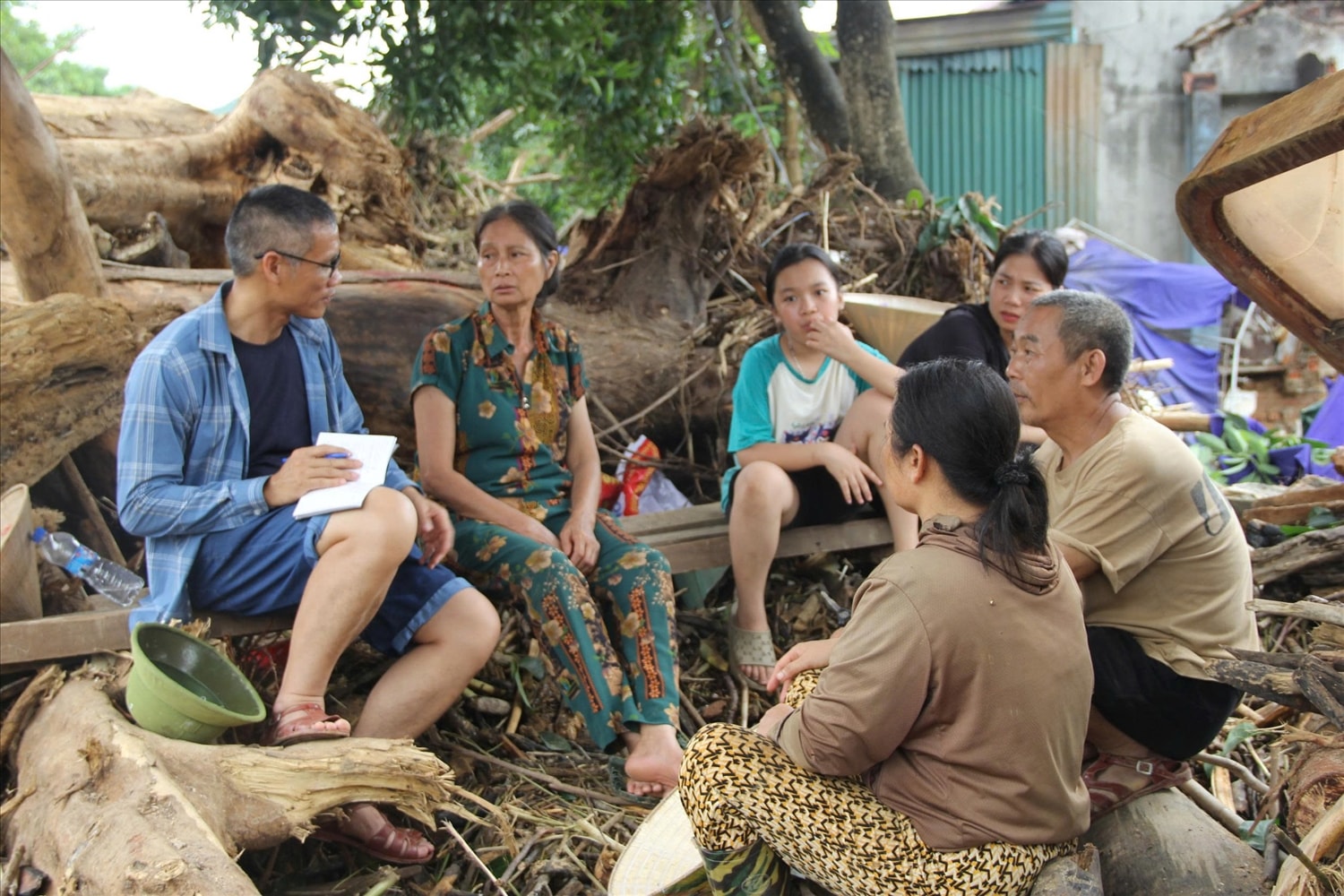 Bà Đậu Thị Hợi (thứ 2 trái sang) cùng những hộ dân bản Cửa Rào 2, xã Tương Dương kể lại khoảnh khắc bị lũ cuốn trôi nhà - Ảnh: Việt Hòa