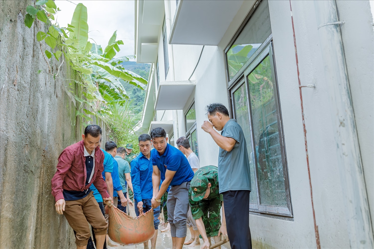Anh Lù Xuân Việt – Bí thư Đoàn Thanh niên xã Thàng Tín cho biết, do khối lượng công việc lớn, Đoàn xã đã huy động hơn 20 đoàn viên tham gia hỗ trợ. Khu vực phía sau dãy lớp học của học sinh khá chật hẹp, không thể đưa máy móc vào, nên toàn bộ công việc đều phải thực hiện thủ công, bằng sức người.