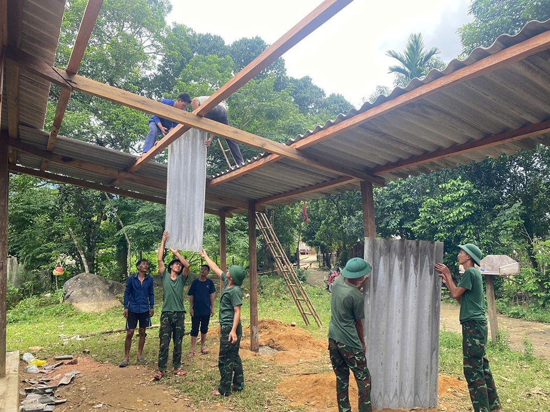Cán bộ, chiến sĩ Bộ Chỉ huy Quân sự tỉnh Quảng Trị hỗ trợ đồng bào làm dàn mát trước sân nhà (Ảnh: Phạm Tiến)