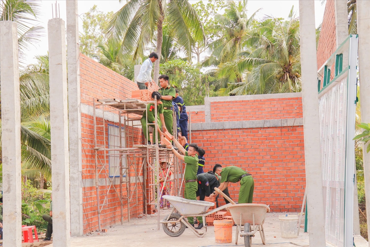 Cán bộ, chiến sĩ Công an tỉnh Vĩnh Long chung tay xoá nhà tạm, nhà dột nát cho bà con Nhân dân. (Ảnh: Thiên Lý)