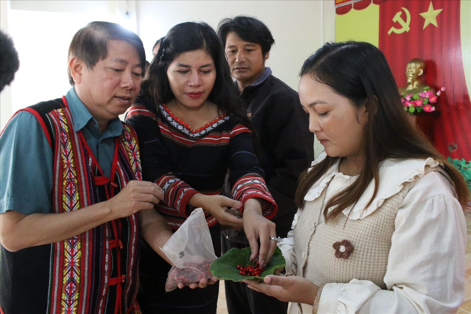 Lãnh đạo xã Măng Ri trao hạt giống sâm Ngọc Linh do các doanh nghiệp hỗ trợ cho đồng bào Xơ Đăng. (Ảnh: Ngọc Chí)