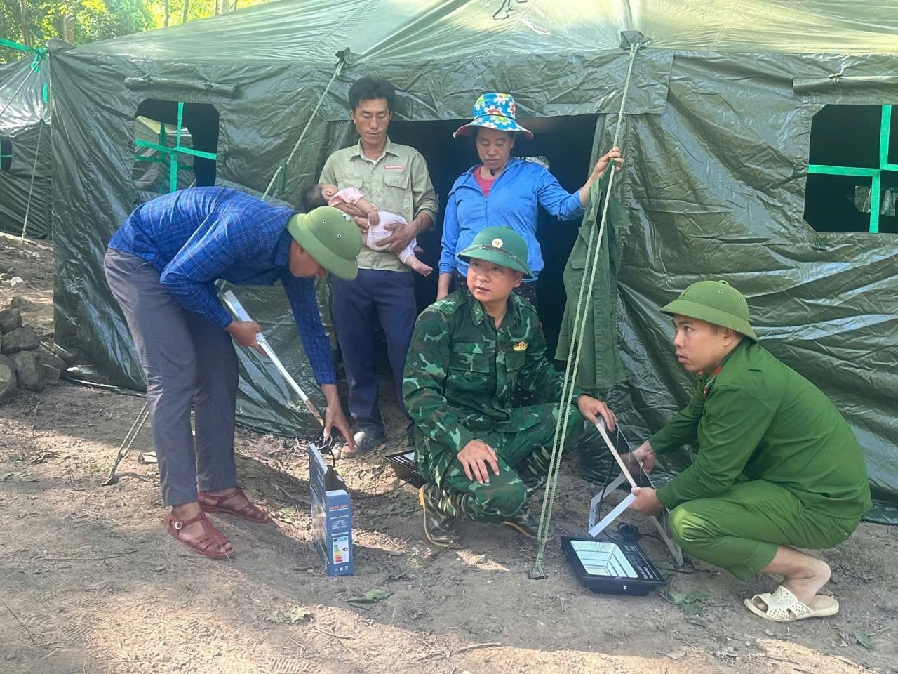 Các lực lượng dựng nhà, lắp đèn năng lượng mặt trời cho người dân mất nhà sau lũ tại xã Nhôn Mai - Ảnh: CSCC