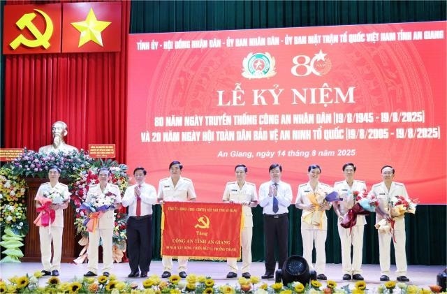 Ông Nguyễn Tiến Hải, Bí thư Tỉnh uỷ và ông Hồ Văn Mừng, Chủ tịch UBND tỉnh trao bức trướng và hoa tặng Ban Giám đốc Công an tỉnh An Giang.