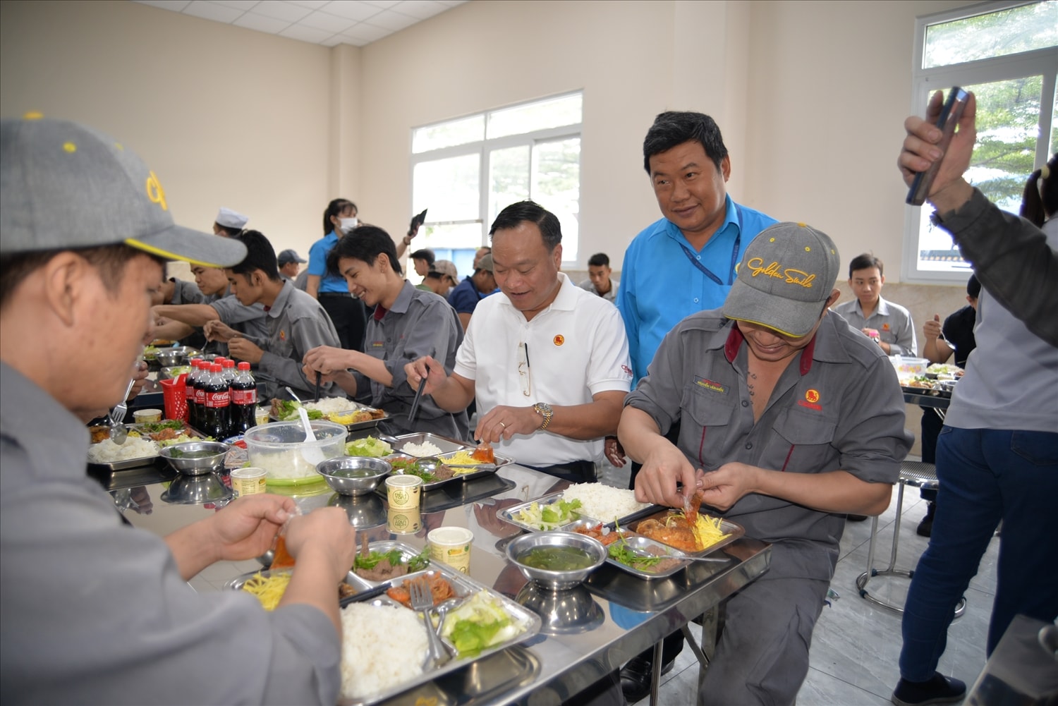 Tổng giám đốc Công ty Casumina Nguyễn Đình Khoát (áo thun trắng) dùng cơm cúng người lao dộng tại Bữa Cơm Công Đoàn