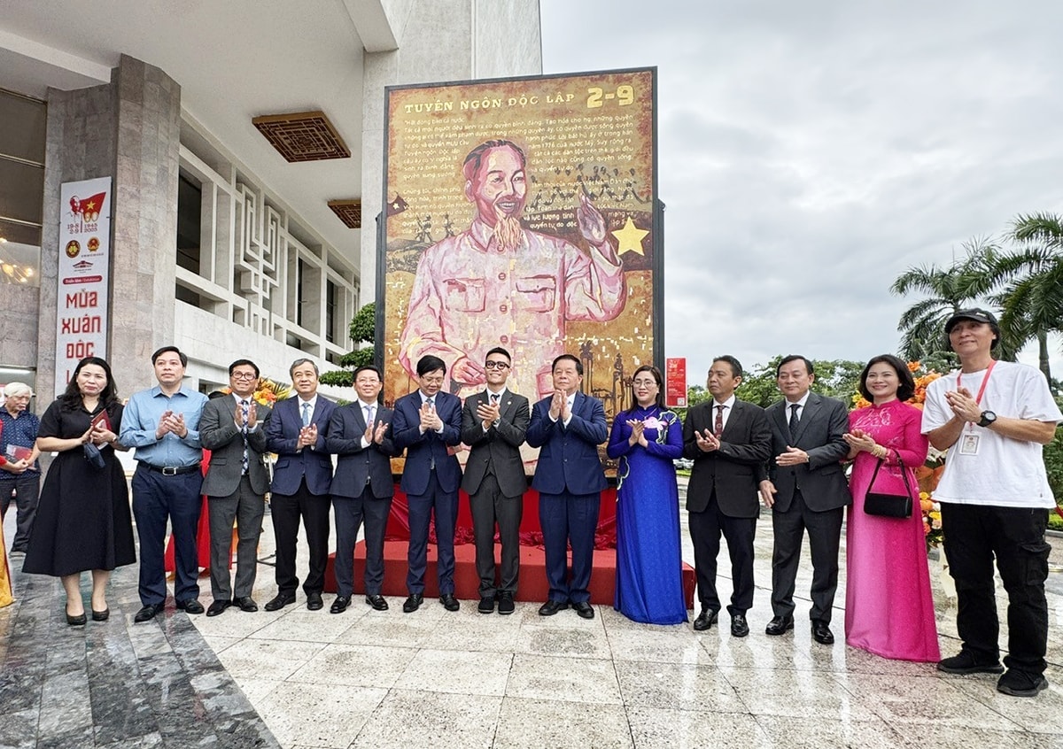 Các đại biểu chụp ảnh cùng tác phẩm Bác Hồ và tác giả - họa sĩ Chu Nhật Quang (đứng giữa) 