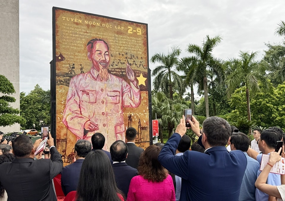 Giây phút trang trọng khi bức tranh Bác Hồ - bức tranh đầu tiên được mở, mở ra hành trình nghệ thuật “Mùa Xuân Độc Lập”. Tác phẩm được vẽ lại từ bức ảnh Chân dung Hồ Chủ tịch, do gia đình cố Nhà báo - Nghệ sĩ nhiếp ảnh Mai Nam - tác giả bức ảnh, trao tặng
