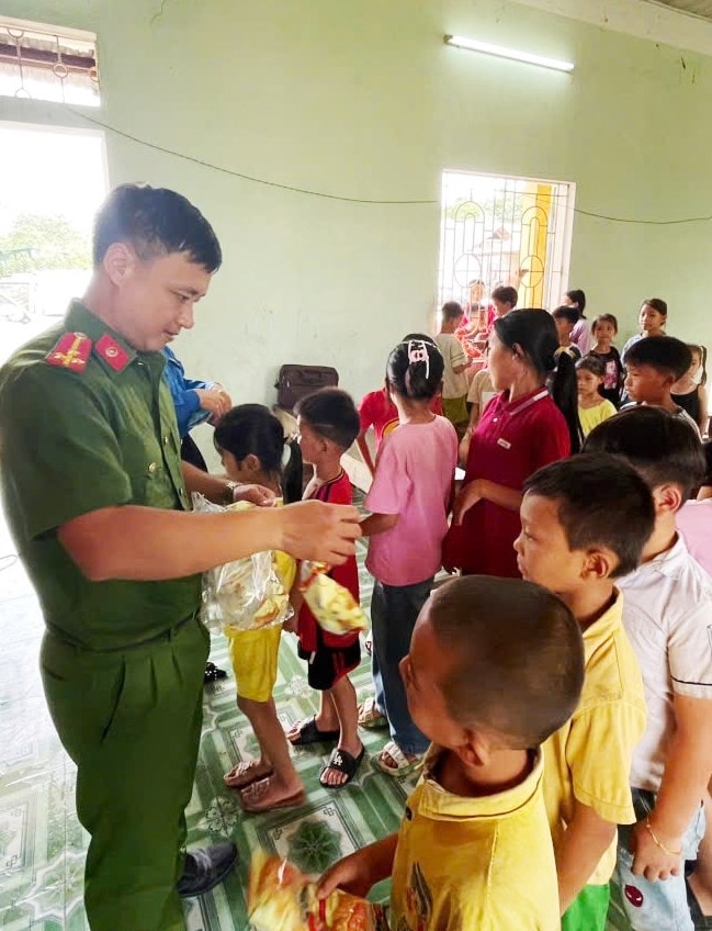 Thượng úy Lý Văn Hòa phát kẹo cho các cháu Trường Mầm non  xã Tân Mỹ nhân dịp Ngày Quốc tế Thiếu nhi 1/6/2025