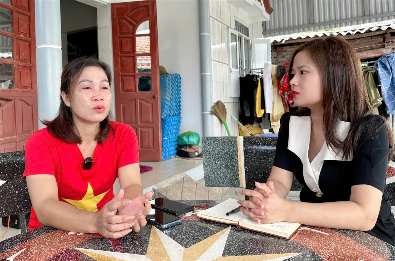 Người có uy tín, Bí thư Chi bộ kiêm Trưởng thôn Hà Tràng Tây (áo đỏ) chia sẻ với phóng viên báo VietNamNet