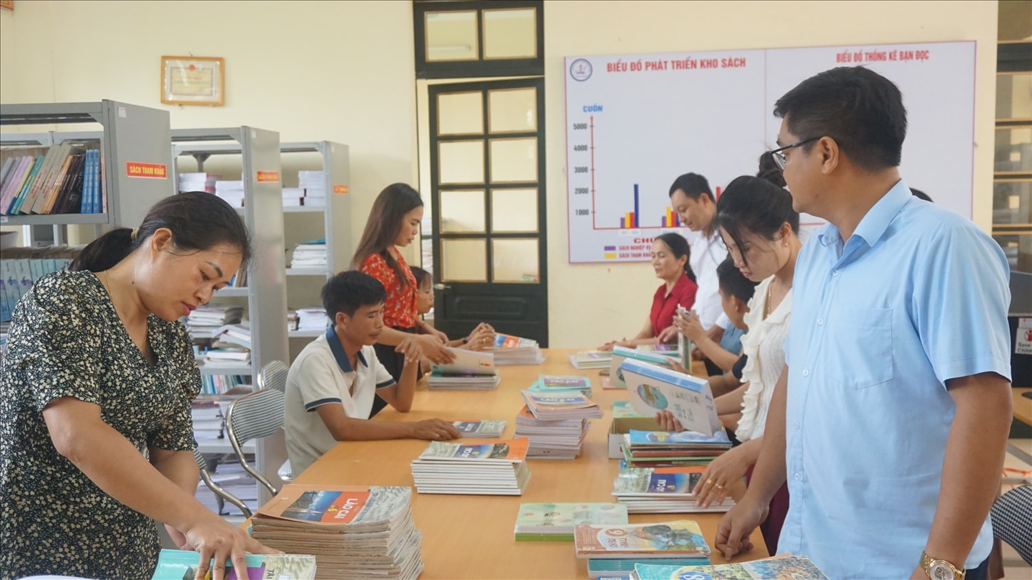 Giáo viên Trường Phổ thông Dân tộc bán trú THCS Trịnh Tường kiểm tra sách giáo khoa chuẩn bị cho năm học mới (ảnh Trọng Bảo)